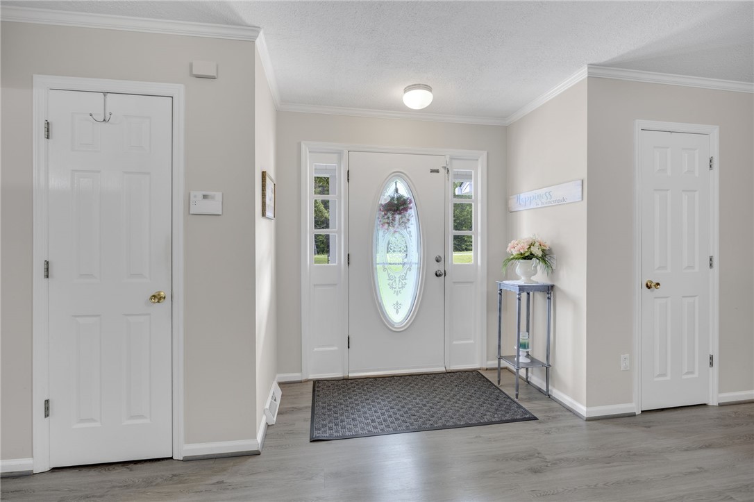 250 Rockcrest Road Cleveland, SC 29635 - Photo 8 of 37 An inviting entry showcases a decorative front door with sidelight windows, flanked by two panel doors and sleek wood-look flooring.