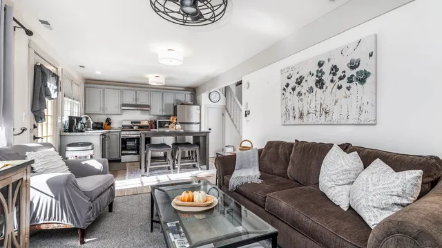 a living room with furniture and a view of kitchen