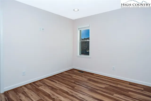 a view of a room with wooden floor and white walls