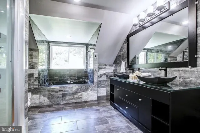 a bathroom with a granite countertop sink a mirror and a shower