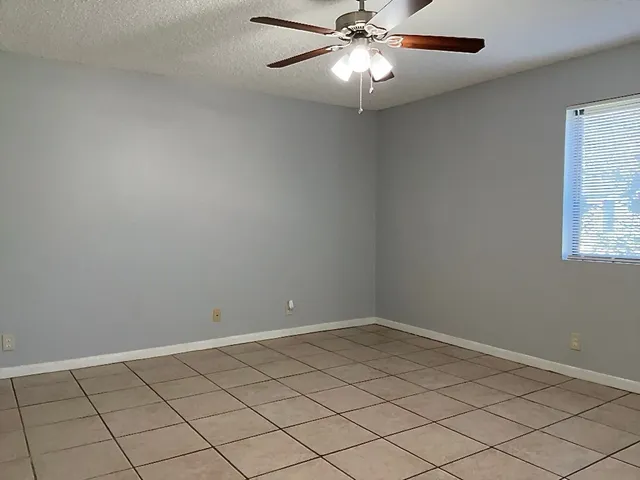 an empty room with a chandelier fan