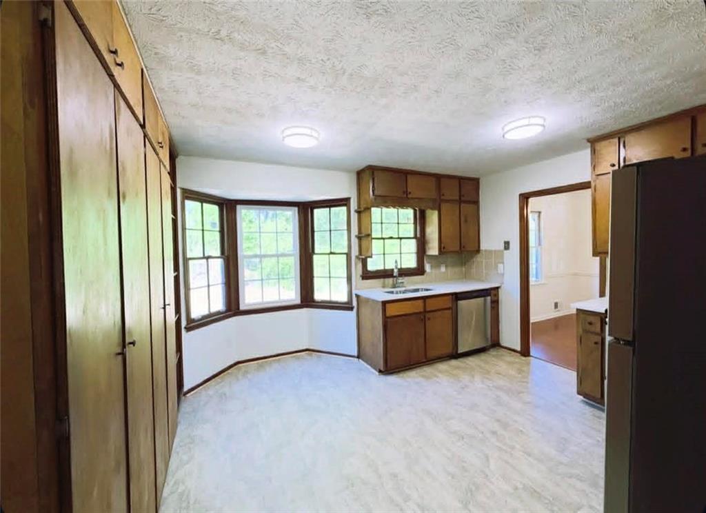 500 Rue De Chateau Stone Mountain, GA 30083 - Photo 6 of 17 a large kitchen with a refrigerator and wooden cabinets