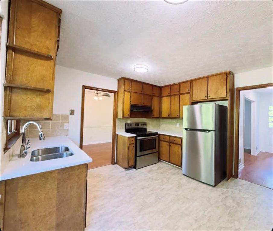 500 Rue De Chateau Stone Mountain, GA 30083 - Photo 7 of 17 a kitchen with a refrigerator sink and wooden cabinets
