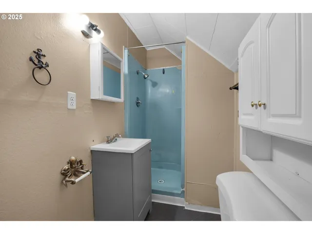 a bathroom with a granite countertop sink a toilet and shower