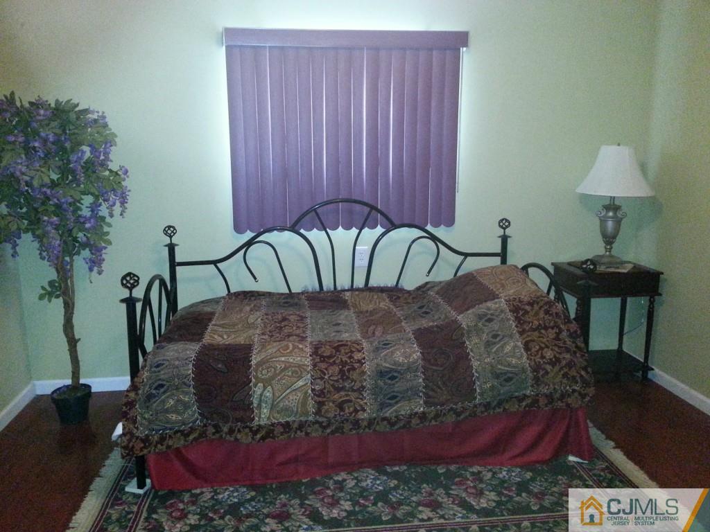 26 Winthrop Road Edison, NJ 08817 - Photo 9 of 25 a bed sitting in a bedroom next to a lamp and a potted plant