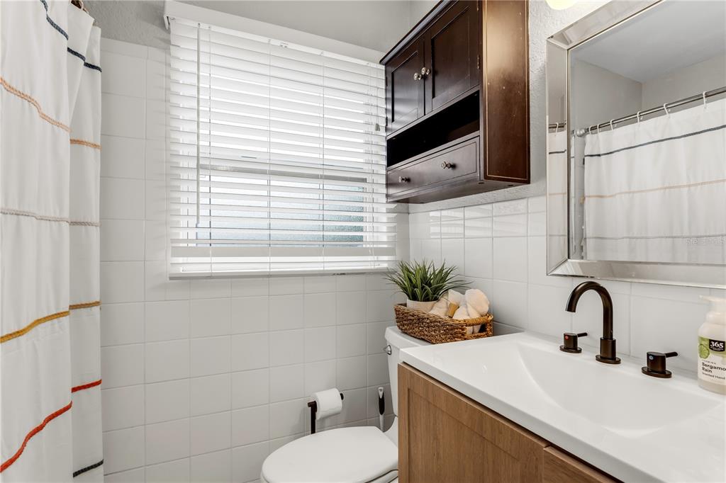 2425 36th Avenue North St. Petersburg, FL 33713 - Photo 23 of 32 a bathroom with a sink a toilet and mirror