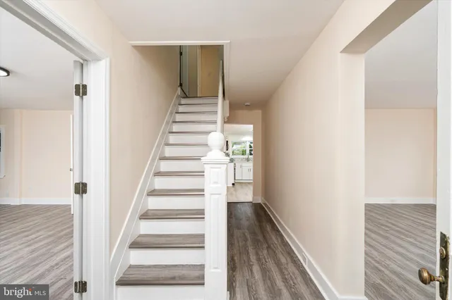 a view of staircase with wooden floor and white walls
