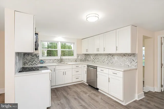a kitchen with granite countertop cabinets stainless steel appliances a sink and a window