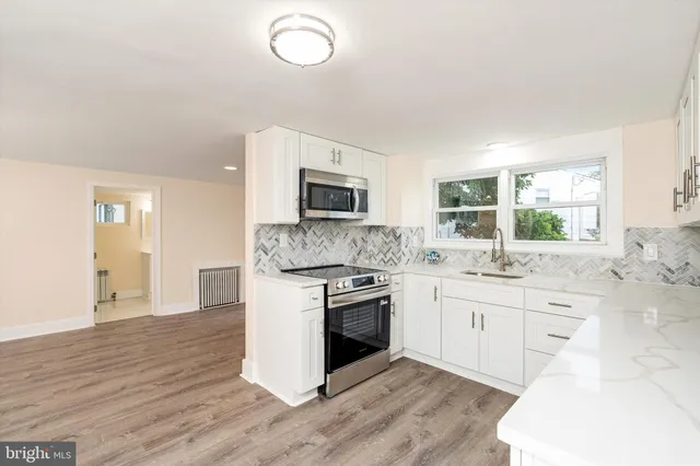 a kitchen with granite countertop a stove top oven sink and cabinets
