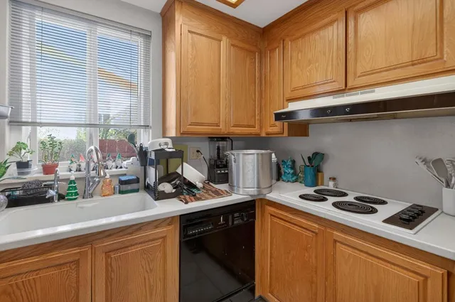 a kitchen with a stove cabinets and a window