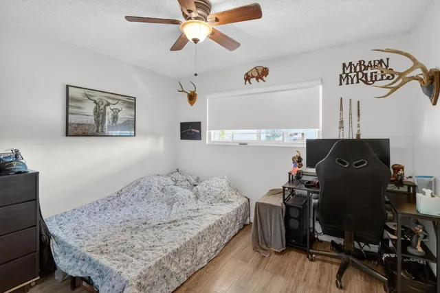 a bedroom with a bed and wooden floor