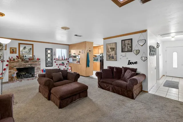 a living room with furniture a fireplace and a large window