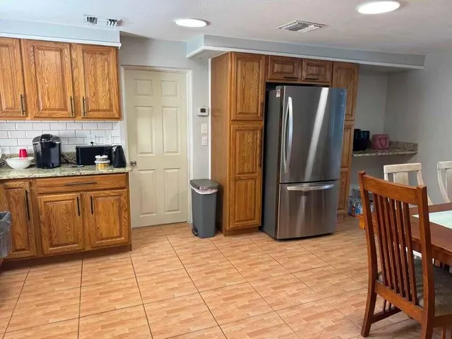 a kitchen with granite countertop a refrigerator a stove a sink a washer and dryer