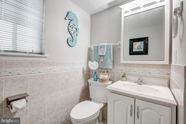 a bathroom with a granite countertop toilet sink and mirror