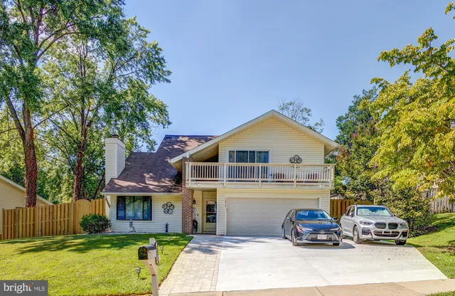 a front view of a house with cars parked