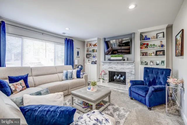 a living room with furniture a flat screen tv and a fireplace