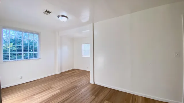 a view of a room with wooden floor and windows