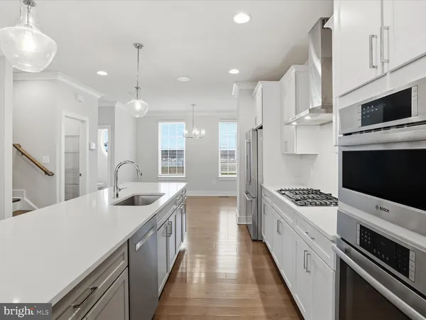 a kitchen with stainless steel appliances a stove a sink and a refrigerator