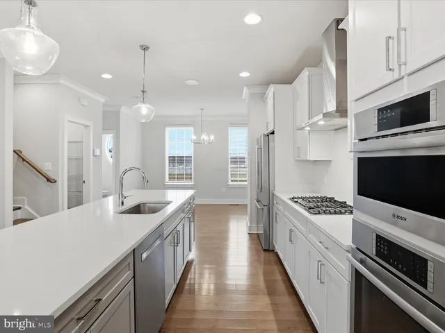 a kitchen with stainless steel appliances a stove a sink and a refrigerator