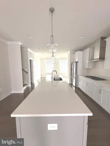 a view of a kitchen with a sink wooden cabinets and stainless steel appliances