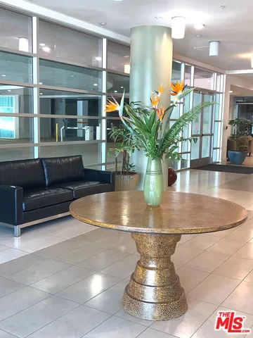 a living room with furniture a rug and a wall painting