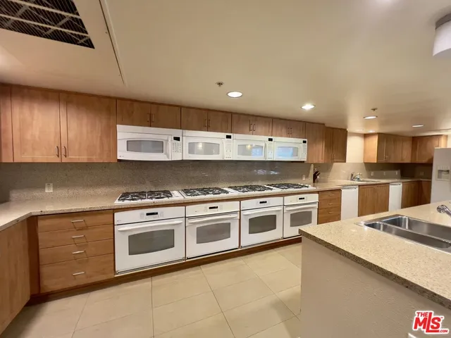 a living room with furniture kitchen view and a large window