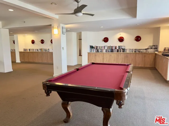 a dining hall with stainless steel appliances a dining table and chairs with wooden floor