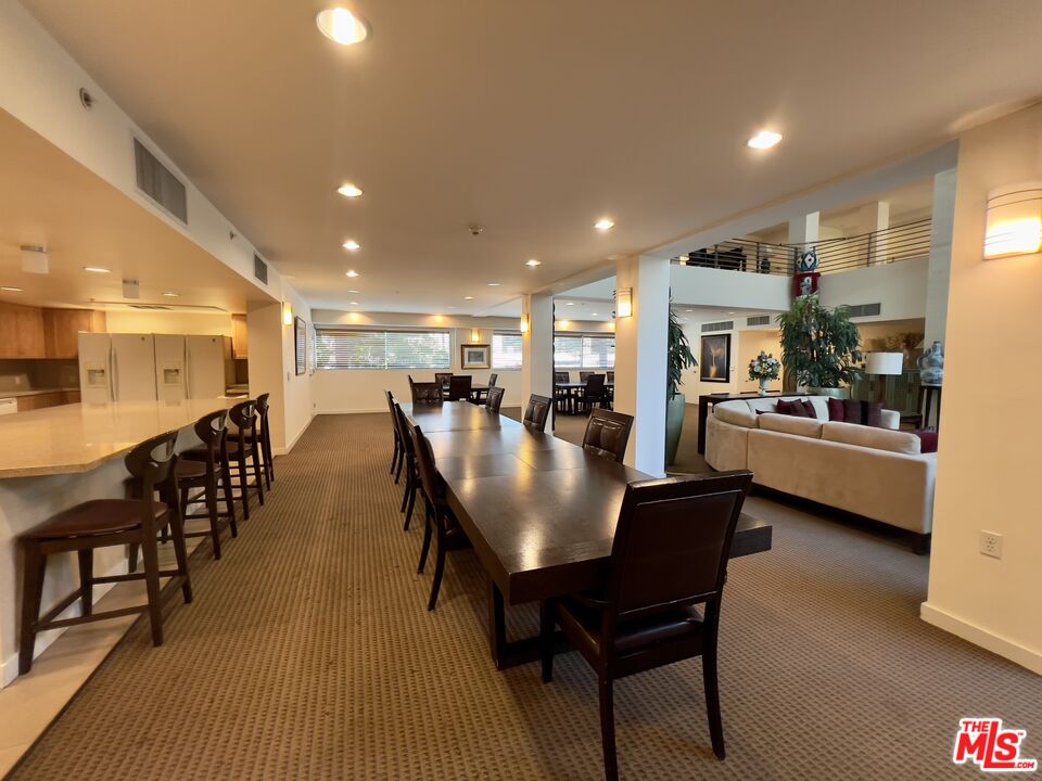 267 San Pedro Street, Unit 221 Los Angeles, CA 90012 - Photo 39 of 45 a dining hall with stainless steel appliances a dining table and chairs with wooden floor