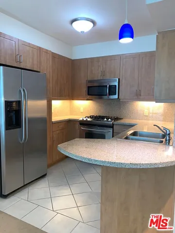 a kitchen with stainless steel appliances granite countertop a sink refrigerator and microwave