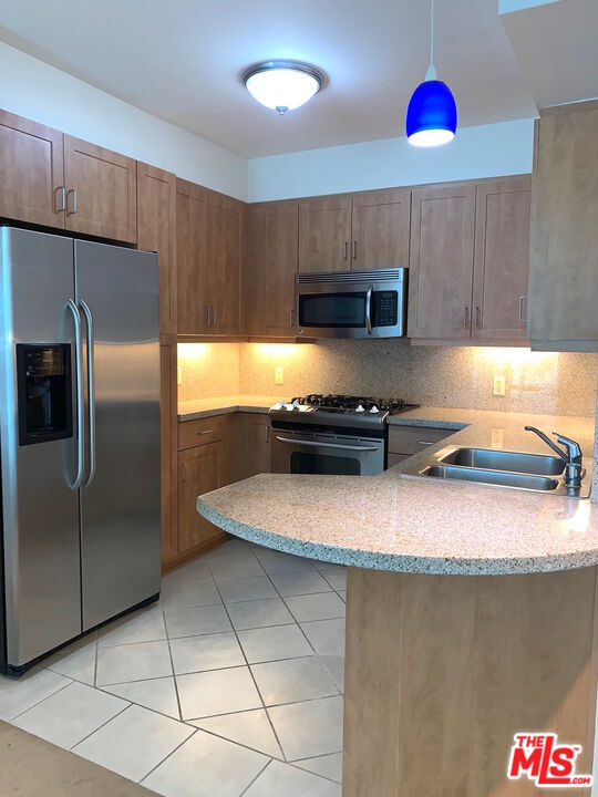 267 San Pedro Street, Unit 221 Los Angeles, CA 90012 - Photo 4 of 45 a kitchen with stainless steel appliances granite countertop a sink refrigerator and microwave