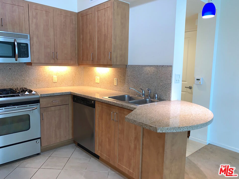 267 San Pedro Street, Unit 221 Los Angeles, CA 90012 - Photo 6 of 45 a kitchen with stainless steel appliances a stove a sink and a microwave