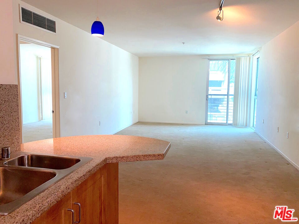 267 San Pedro Street, Unit 221 Los Angeles, CA 90012 - Photo 7 of 45 a kitchen with granite countertop a sink and a window