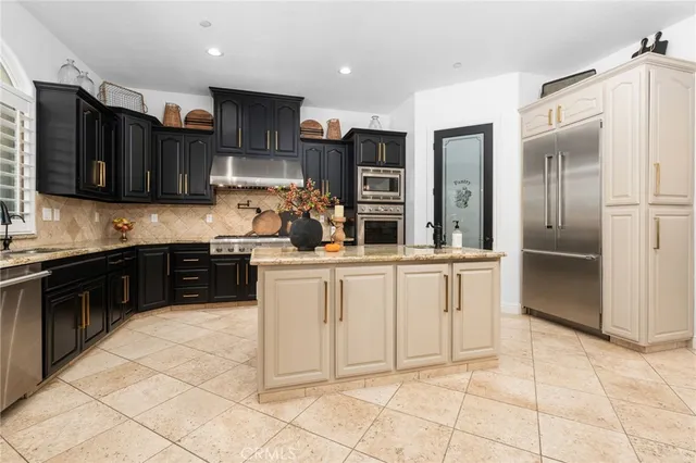 a kitchen with stainless steel appliances granite countertop a refrigerator and a stove top oven