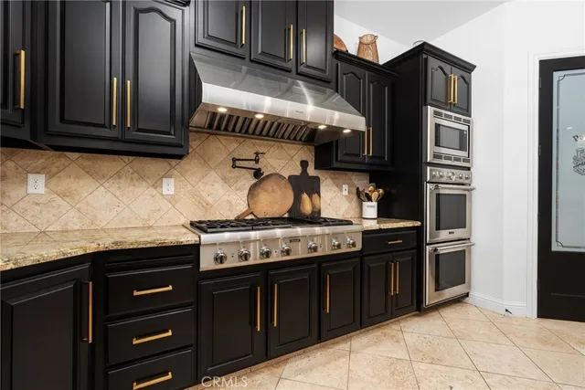 a kitchen with stainless steel appliances granite countertop a stove and a microwave