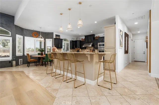 a kitchen with stainless steel appliances kitchen island granite countertop a refrigerator and cabinets