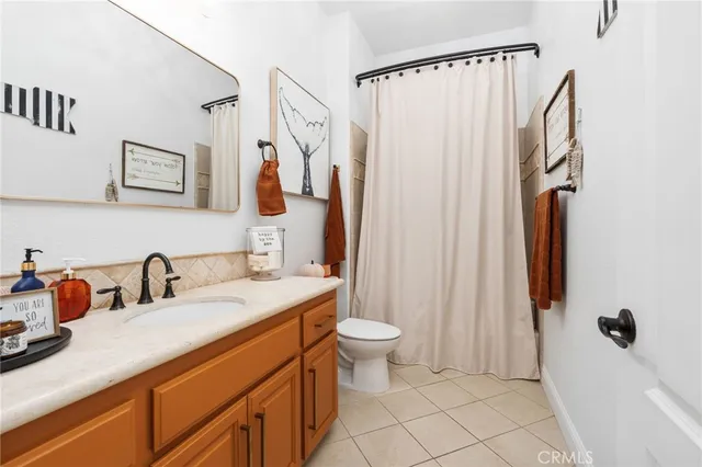 a bathroom with a sink a toilet and shower curtain