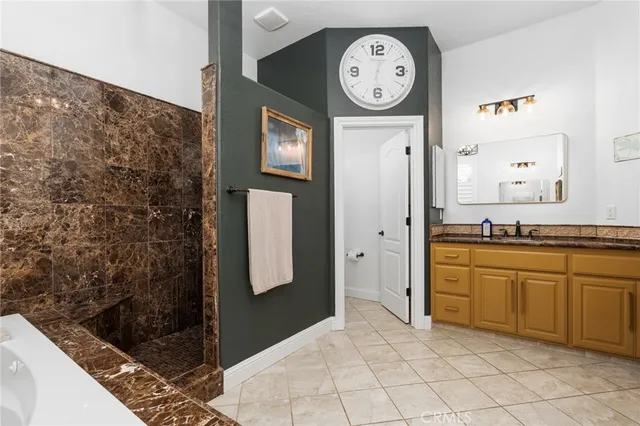 a spacious bathroom with a granite countertop sink and a mirror