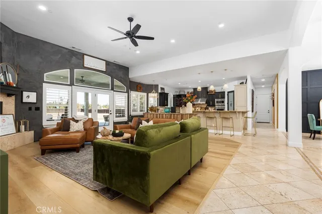 a living room with furniture ceiling fan and a large window