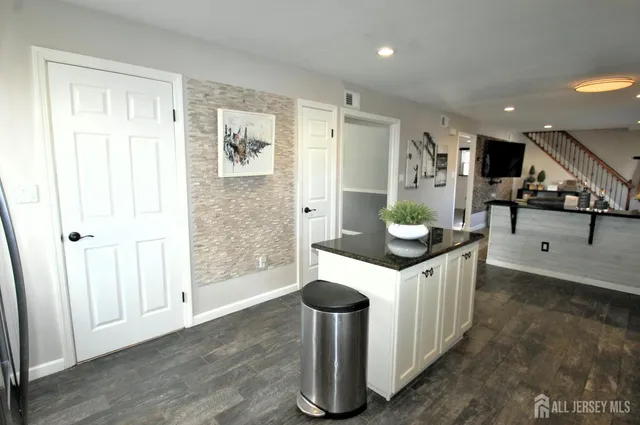 a kitchen with stainless steel appliances granite countertop a lot of cabinets and wooden floor