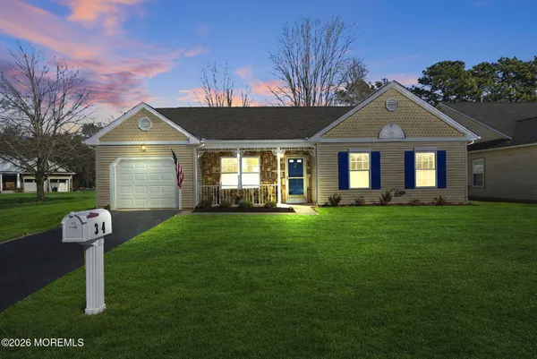 a front view of a house with a yard and green space