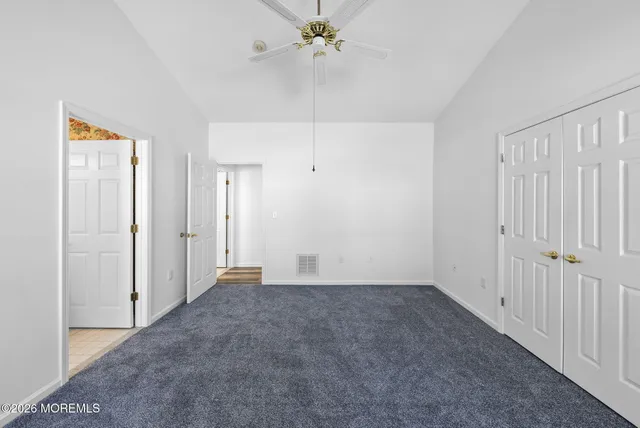 a view of an empty room with a ceiling fan