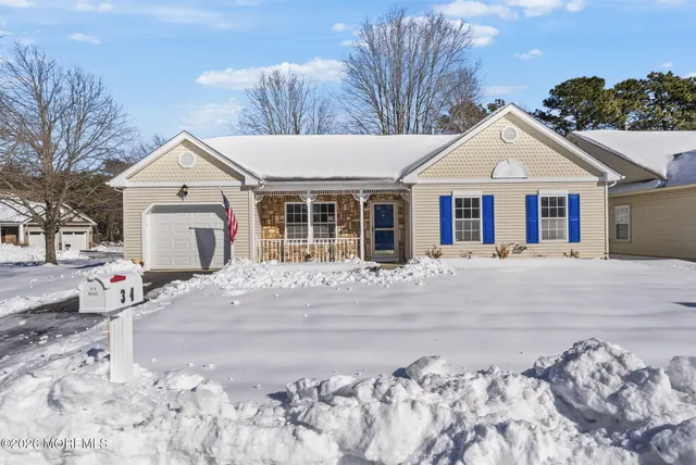 a view of a white house with a yard and large trees