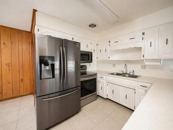 a kitchen with stainless steel appliances a refrigerator sink and cabinets