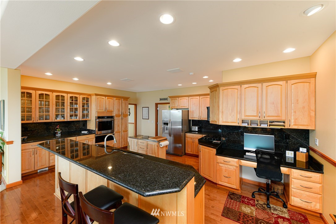 4203 Mitchell Drive Anacortes, WA 98221 - Photo 10 of 38 a kitchen with stainless steel appliances granite countertop a sink counter space dining table and chairs