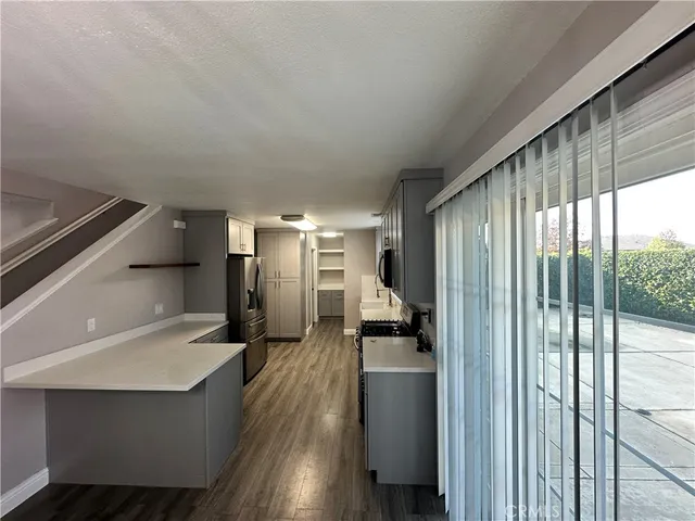 a view of a hallway with wooden floor and a living room