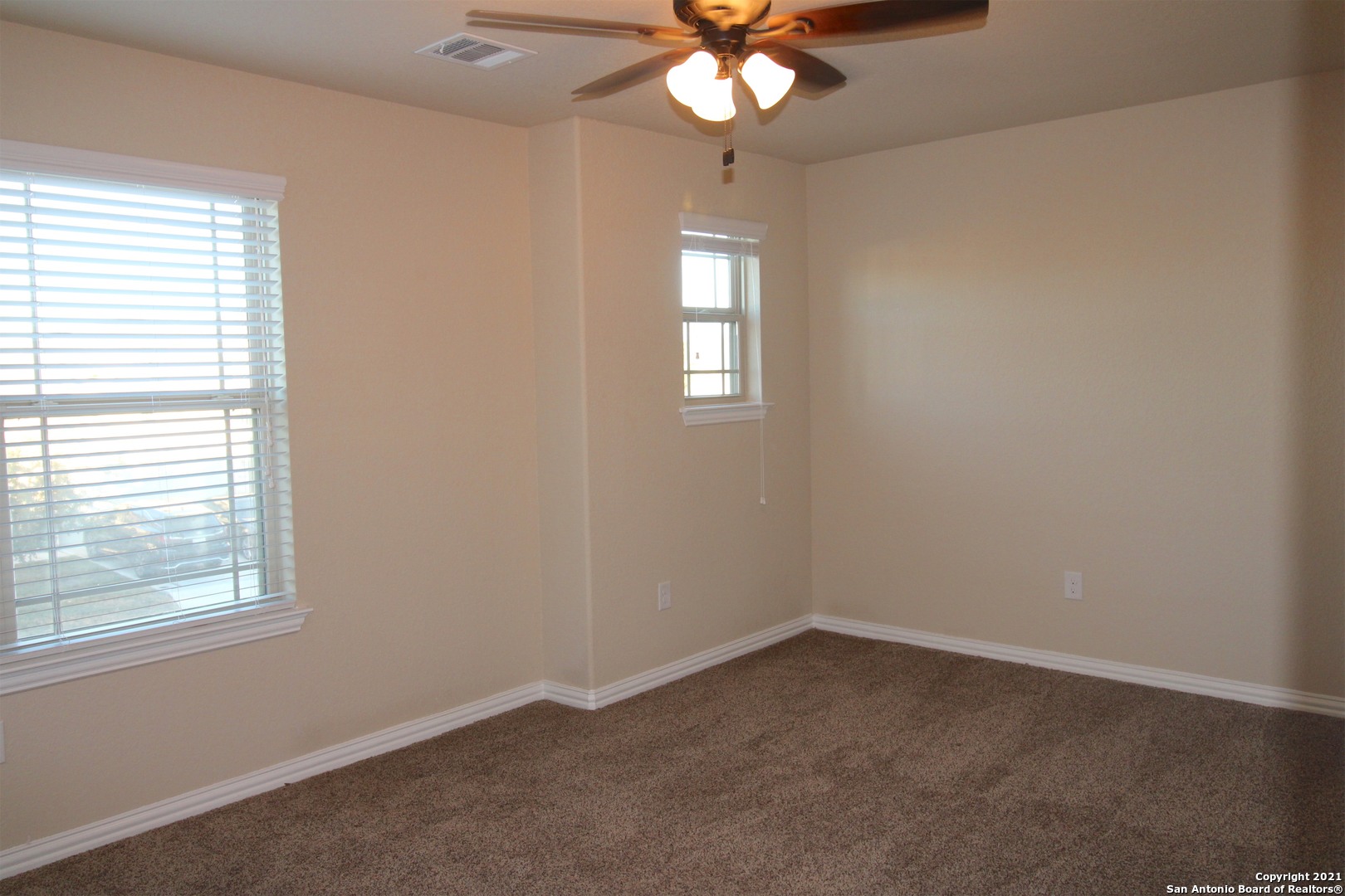 9118 Hogarten Converse, TX 78109 - Photo 20 of 26 an empty room with a chandelier fan and windows