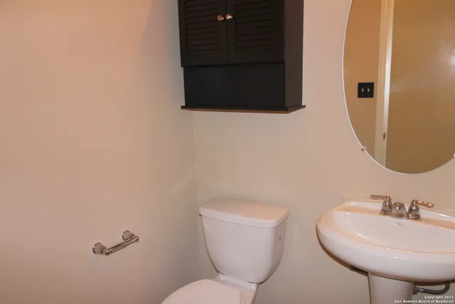 a bathroom with a toilet sink and mirror