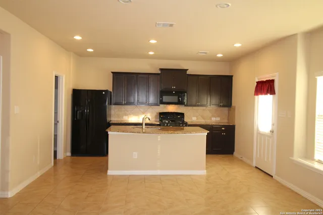 a kitchen with a stove a refrigerator and a sink