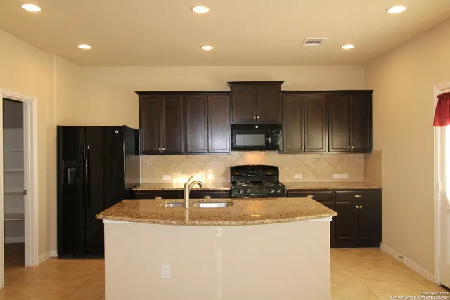 a kitchen with kitchen island stainless steel appliances a sink and a refrigerator