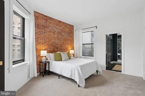 a bedroom with a bed wall painting and a window